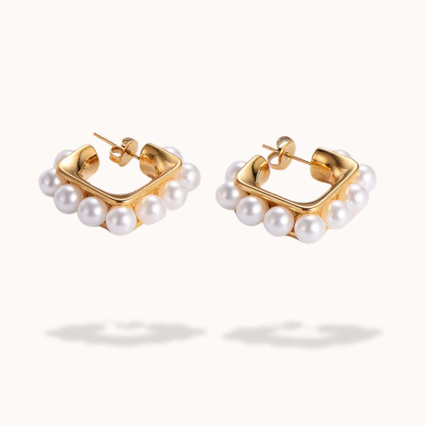Gold hoop earrings with pearl accents on a white background