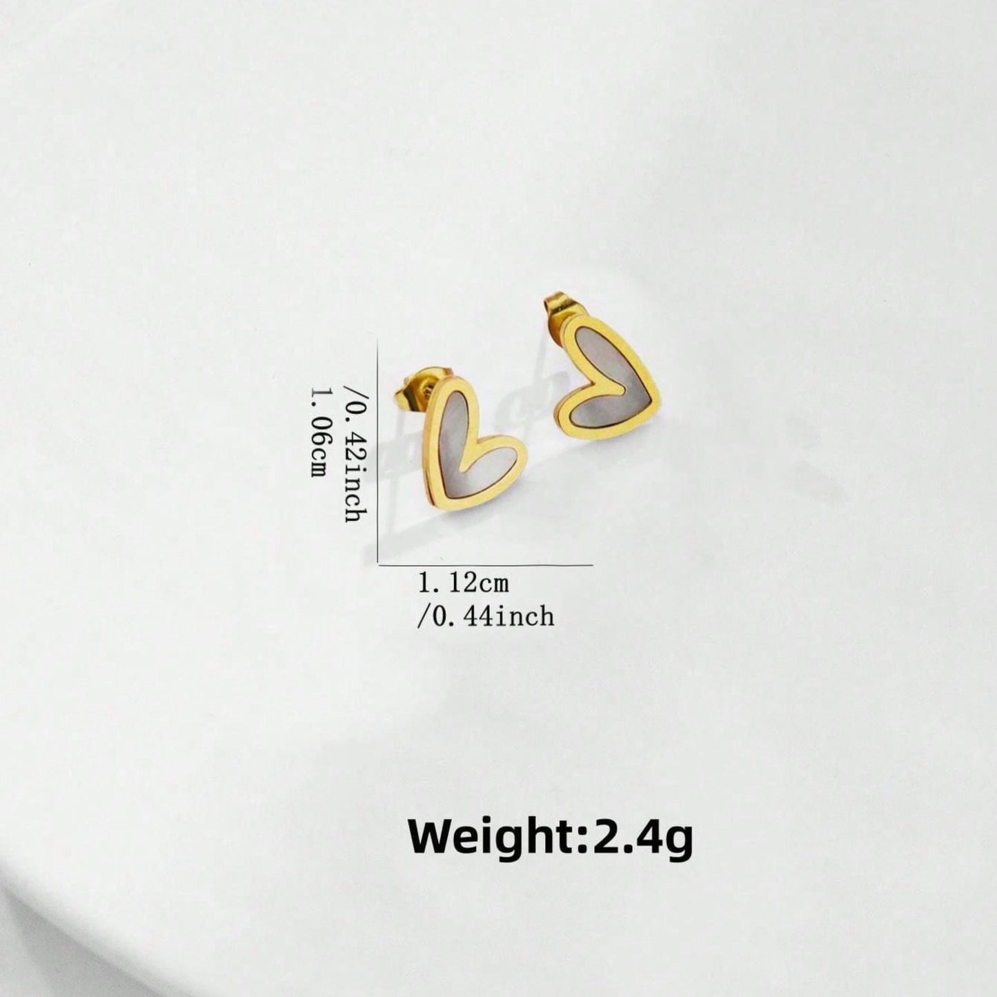Gold heart-shaped white enamel centered earrings with measurements and weight on a white background