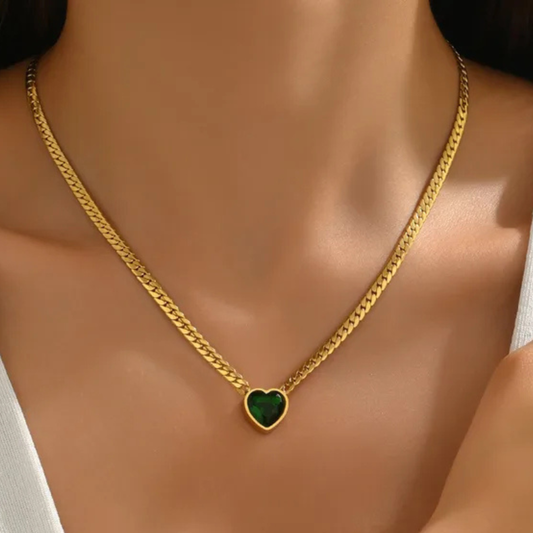 Gold necklace with a green heart pendant on a mannequin