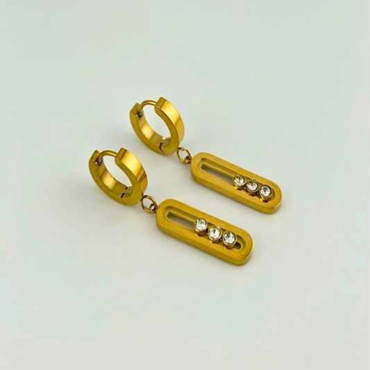 Gold hoop earrings with rectangular drops and embedded stones on a light gray background