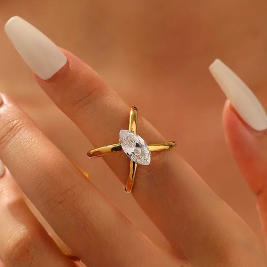 Gold ring with a diamond on a hand against a blurred background