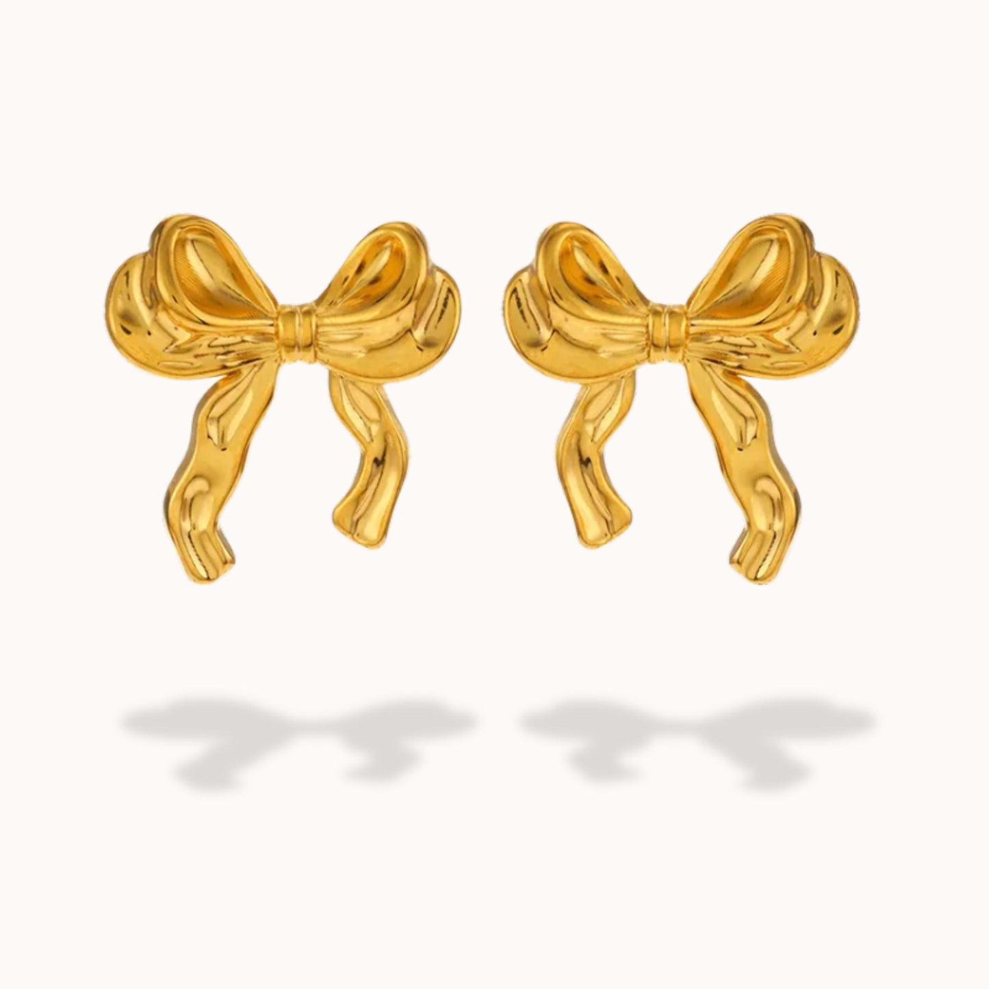 Gold bow-shaped earrings on a white background