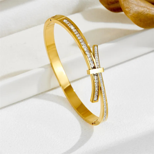 Gold bracelet with diamond accents on a white surface
