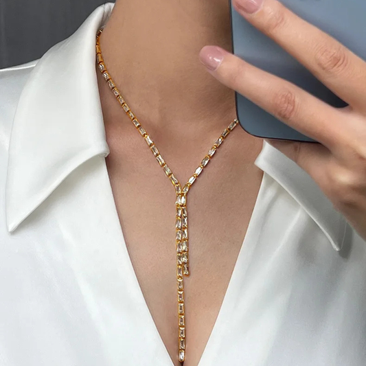 Gold body chain worn by a person with a white shirt and blurred background