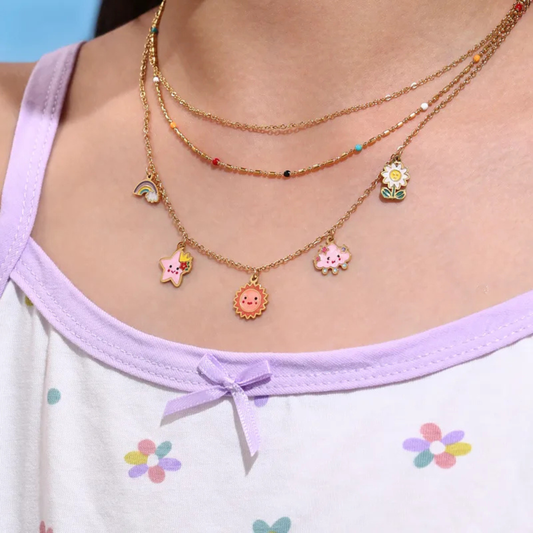 Necklace with colorful charms worn by a person in a light purple top with floral patterns.