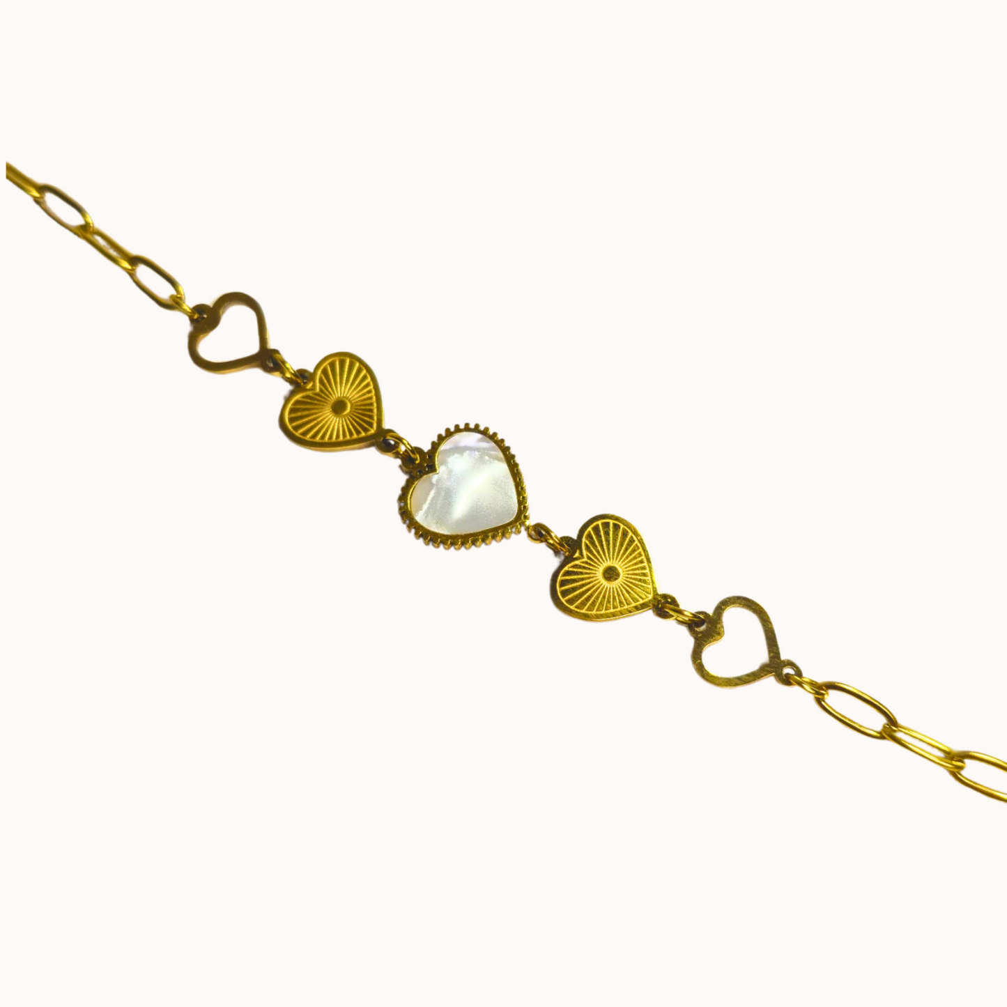 Gold bracelet with heart and circular designs on a white background