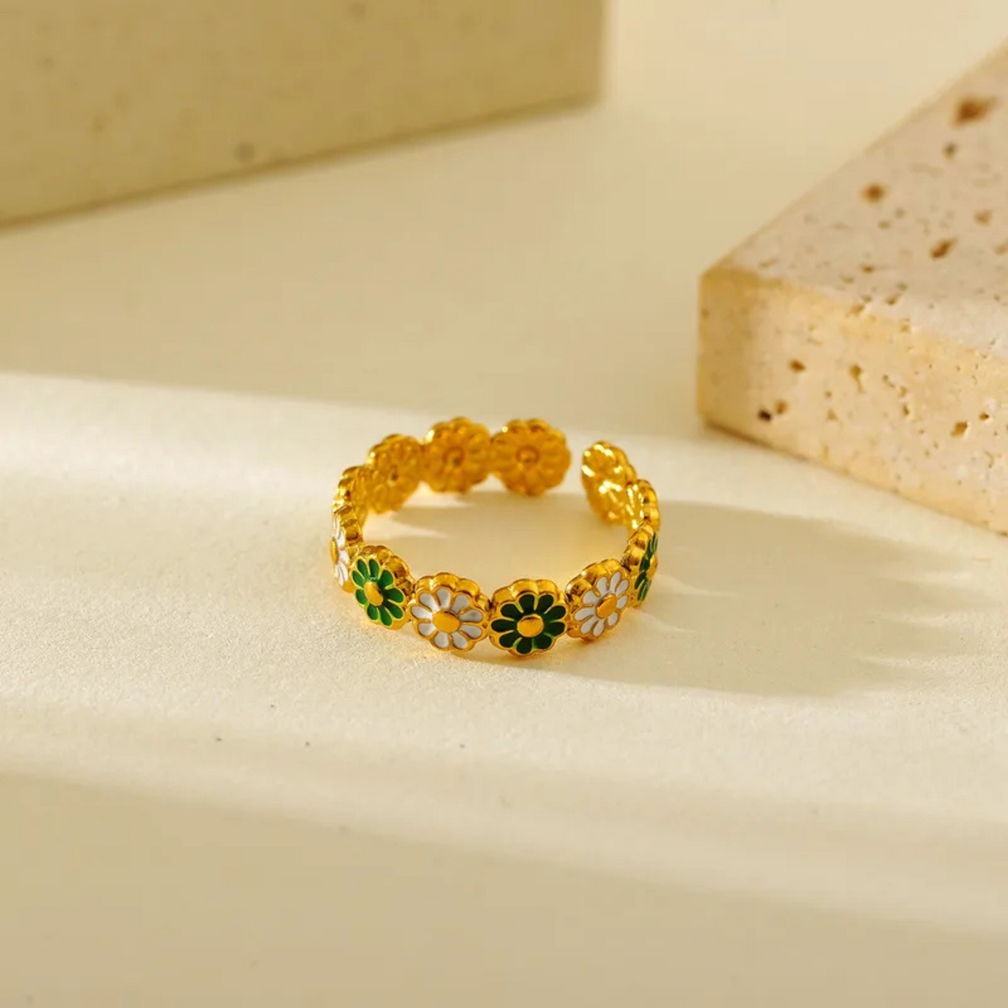 Gold ring with floral designs on a beige background