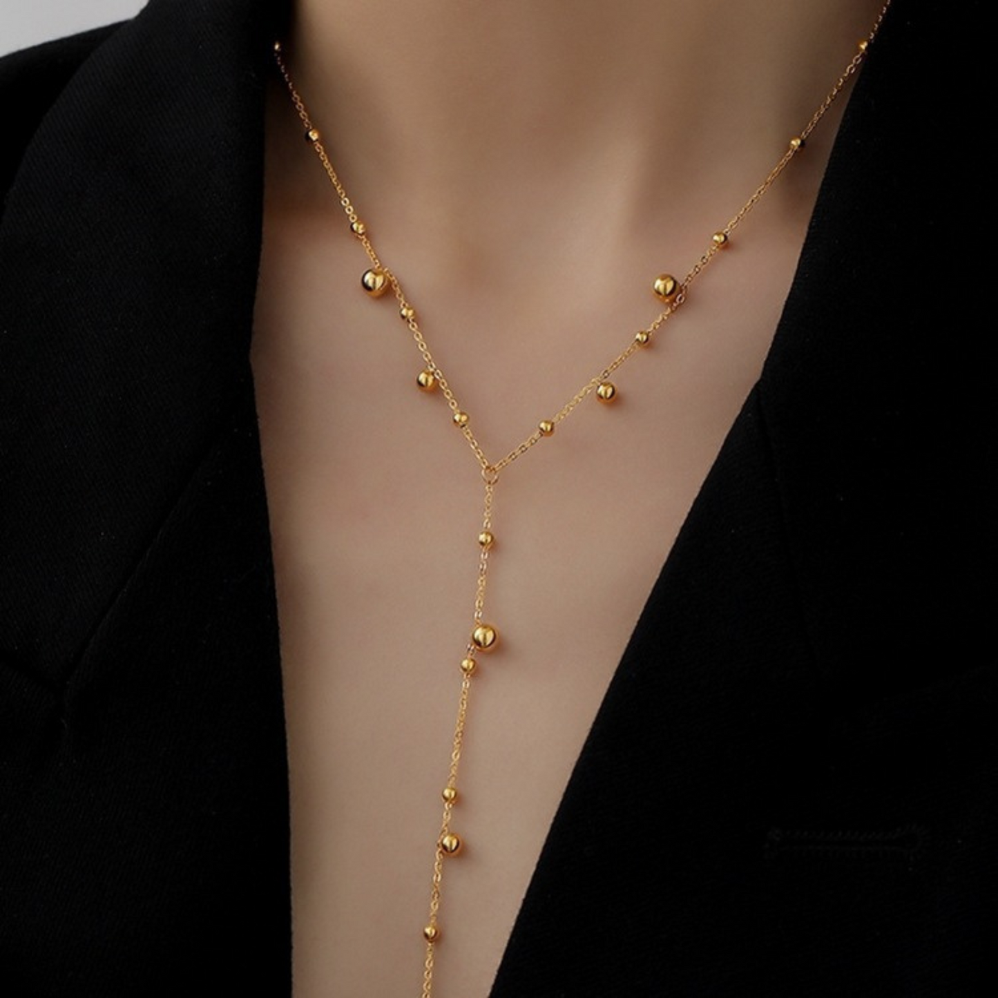 Gold necklace on a mannequin with a black background