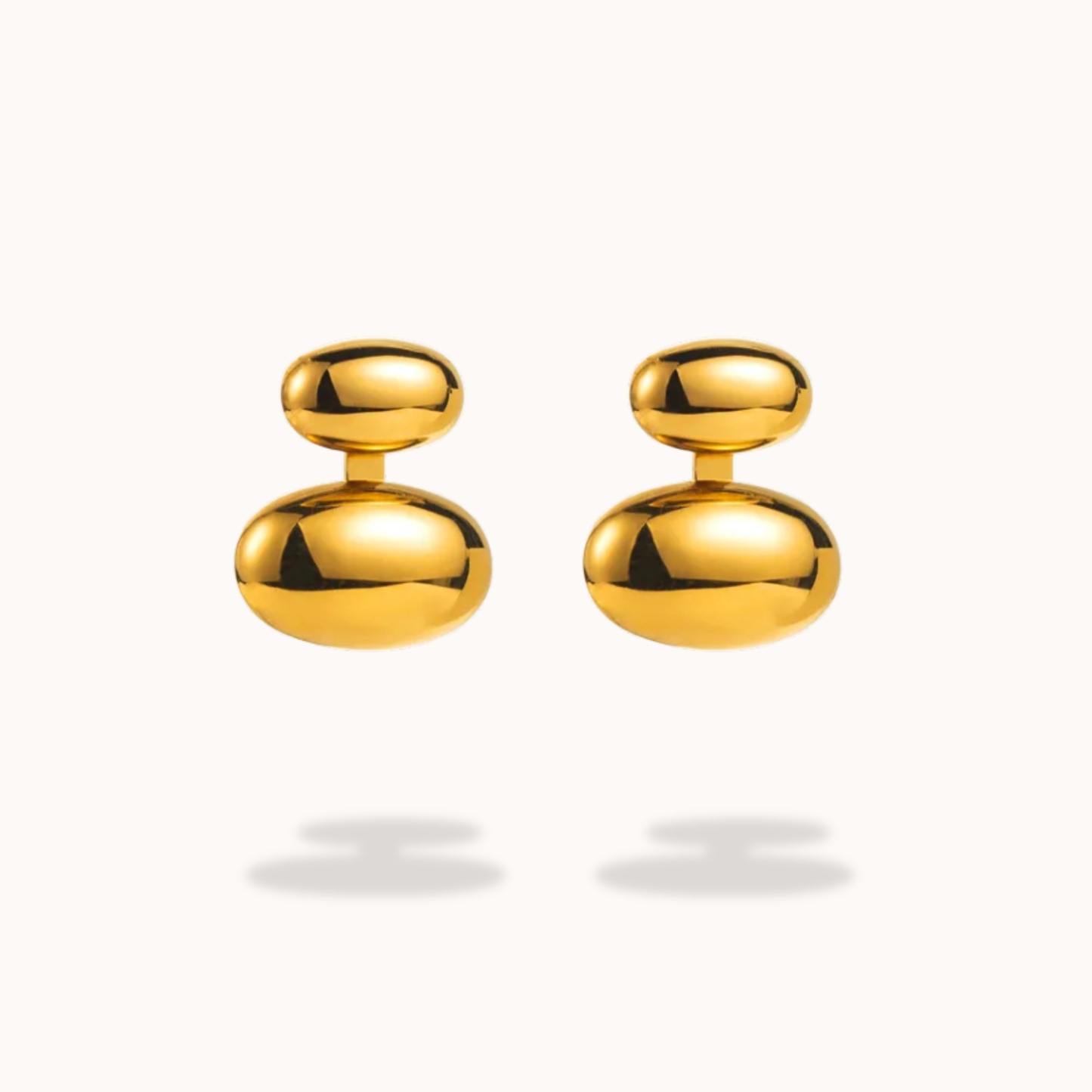 Pair of gold earrings on a light gray background
