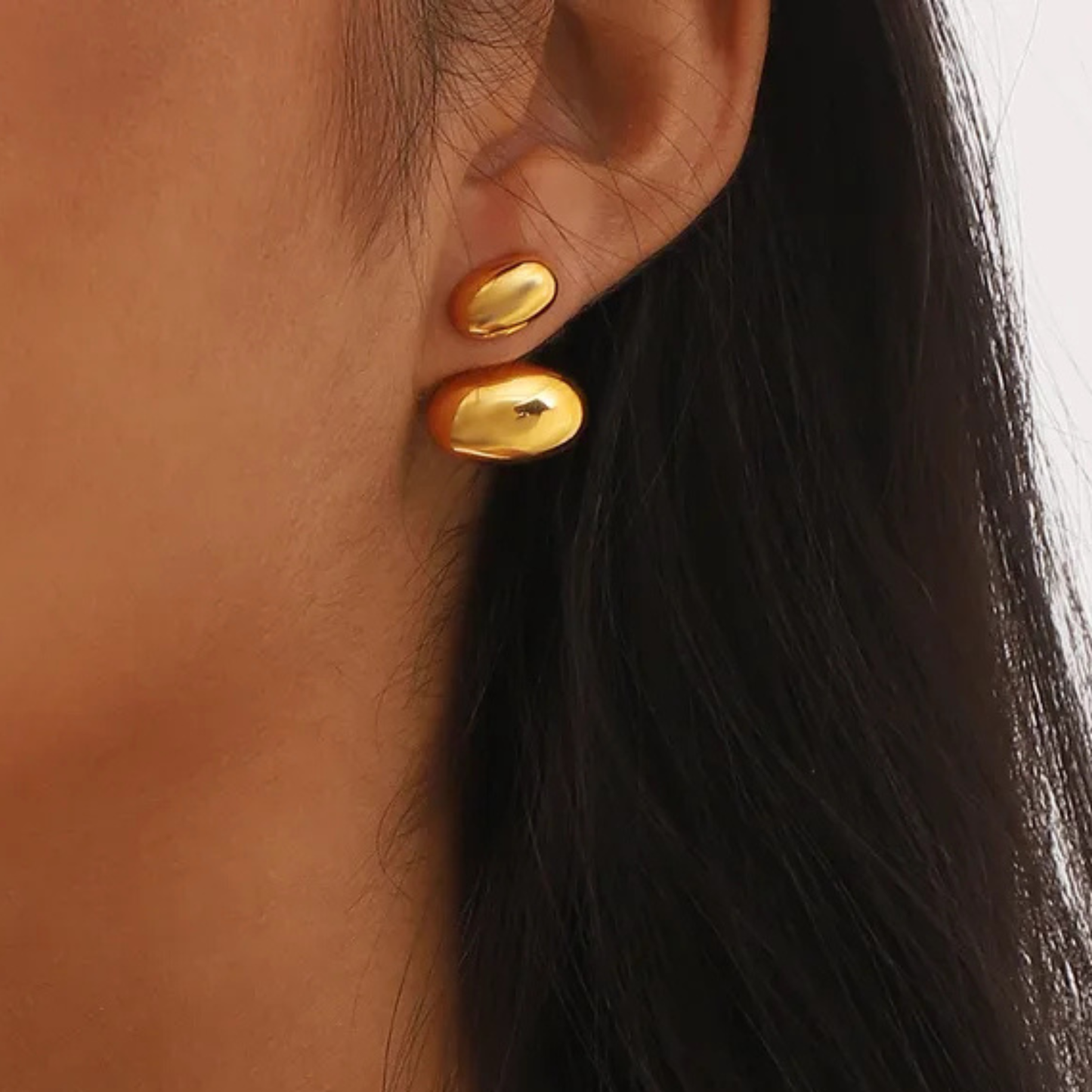 sphere gold earrings on a model