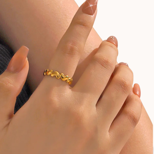 Gold ring on a finger with a soft focus background