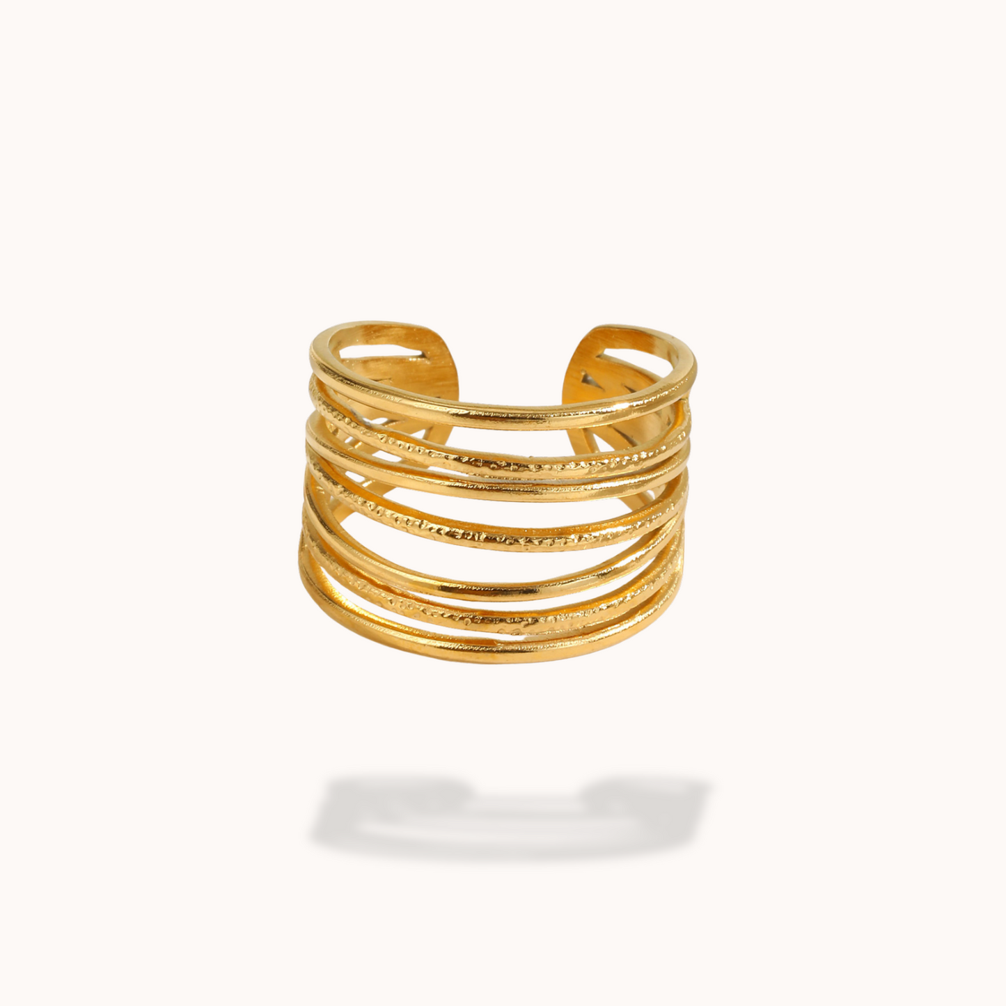 Gold ring with multiple stacked bands on a white background