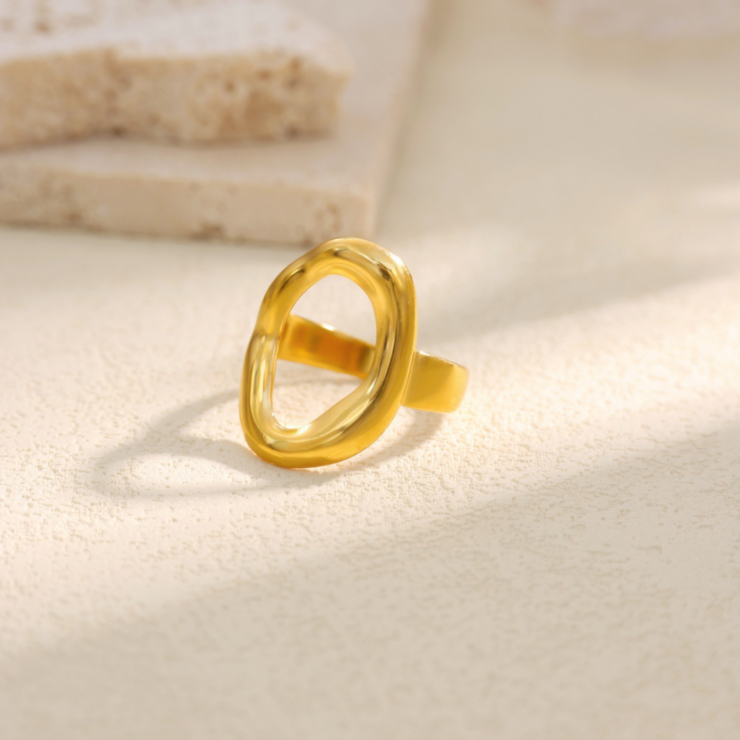 Gold ring on a light beige background