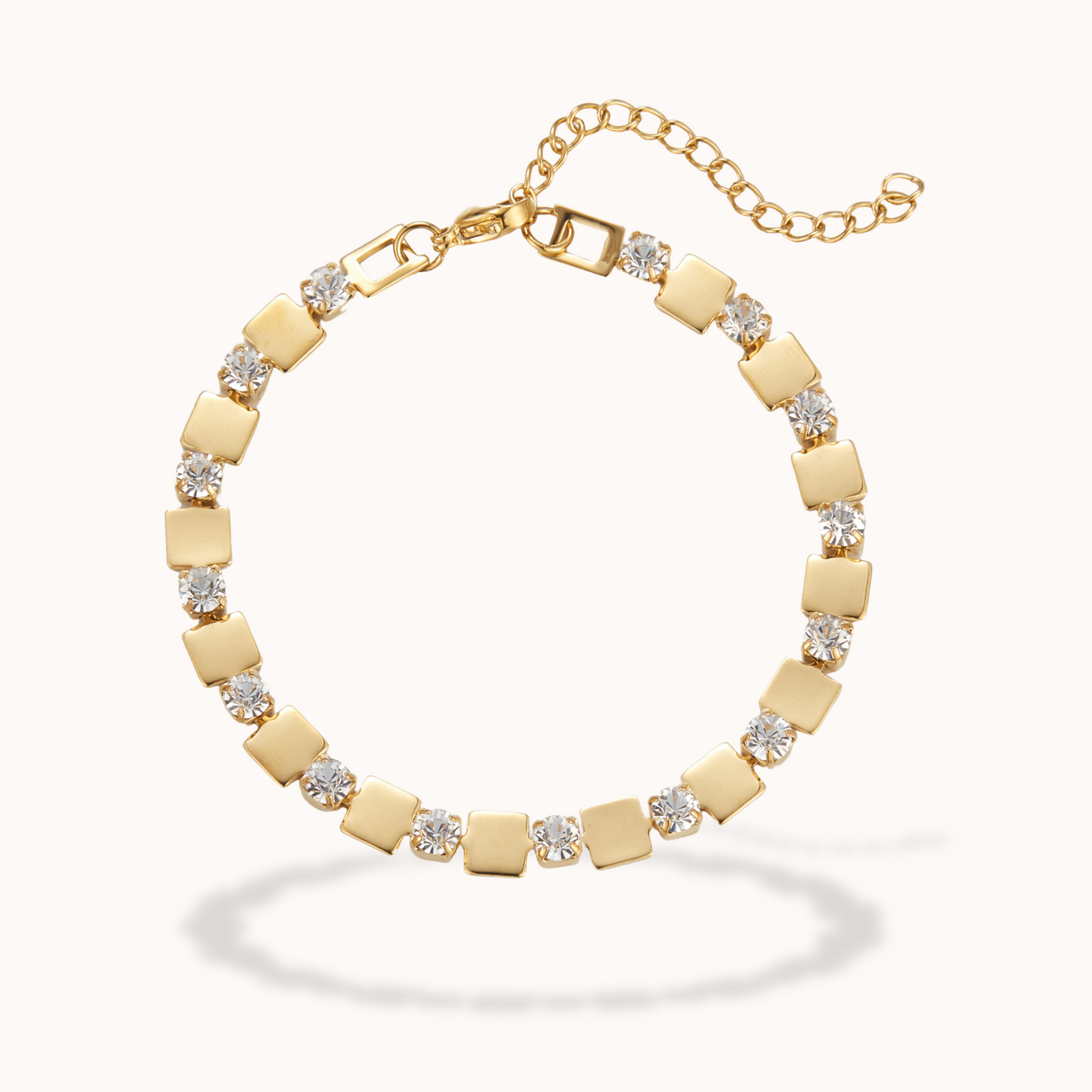 Gold bracelet with square links and clear stones on a white background