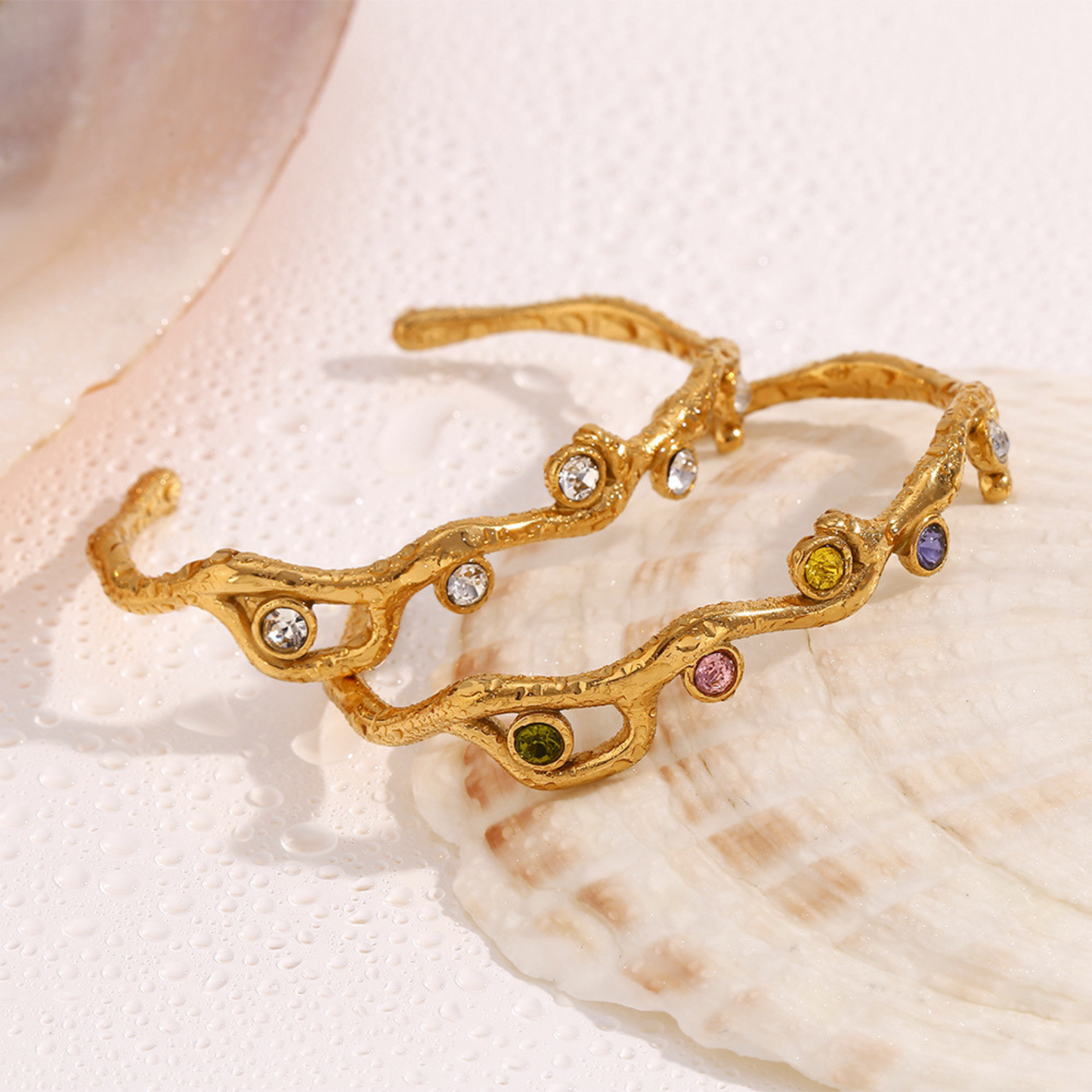 Gold bracelet with colorful gemstones on a seashell