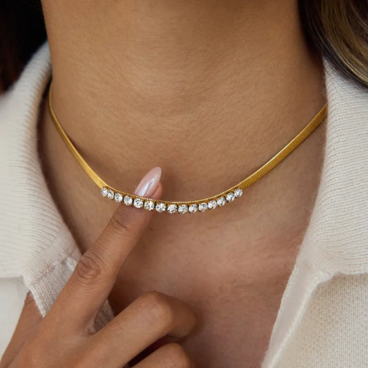 Gold choker necklace with small diamonds worn by a person