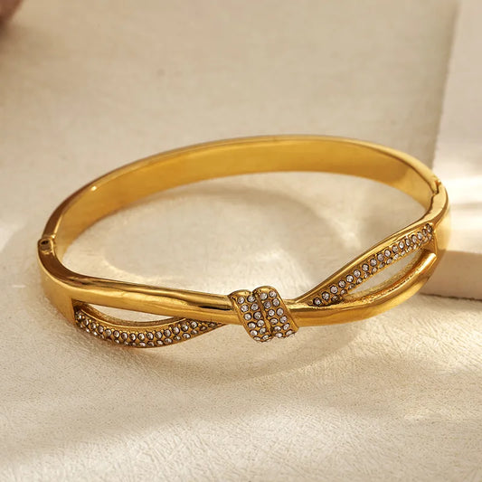 Gold bracelet with diamond accents on a light fabric background
