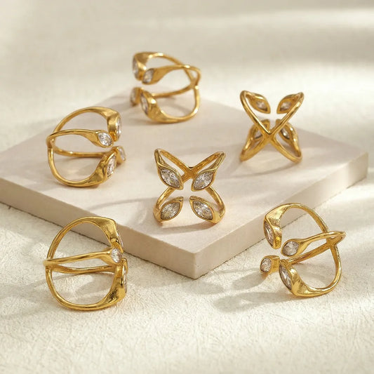 Gold rings with butterfly design on a beige surface