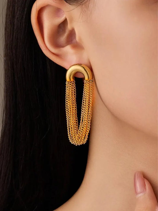 Gold hoop earring worn by a person with dark hair.