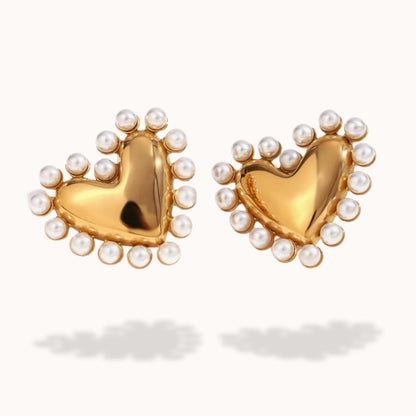 Gold heart-shaped earrings with pearl accents on a white background