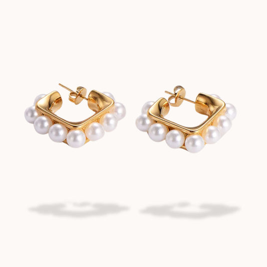 Gold hoop earrings with pearl accents on a white background