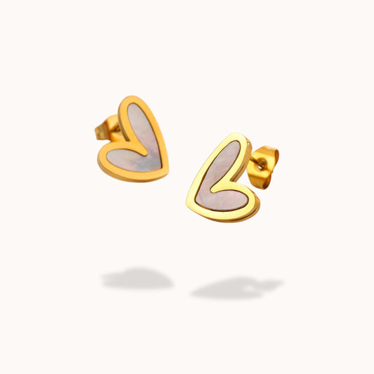 Gold heart-shaped white enamel centered earrings on a white background