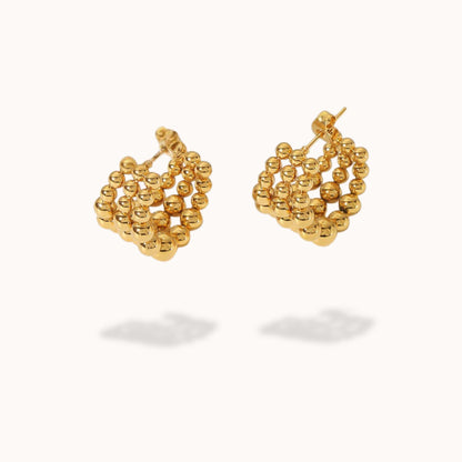 Gold beaded earrings on a white background