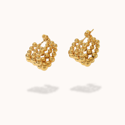 Gold beaded earrings on a white background