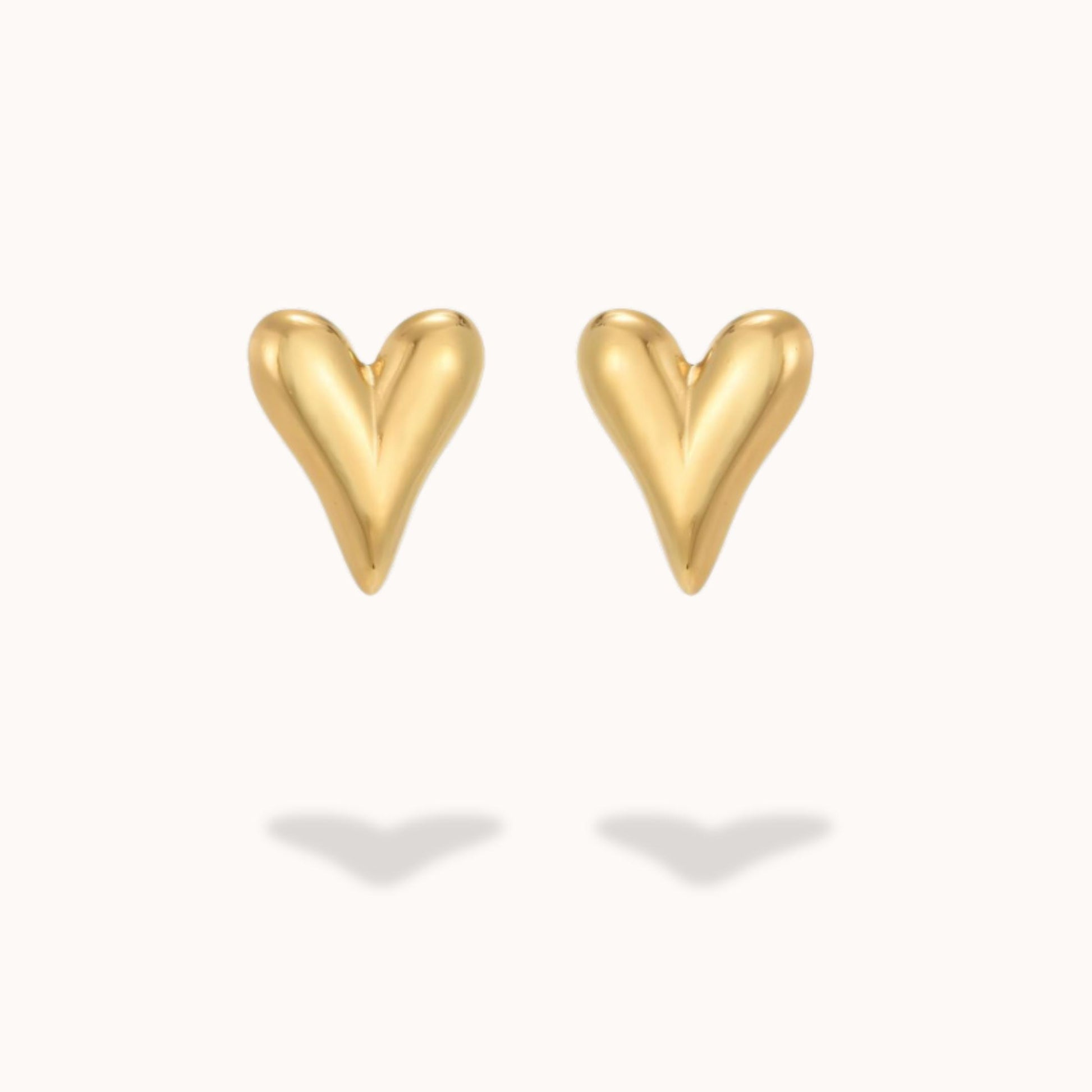 Gold heart-shaped earrings on a white background