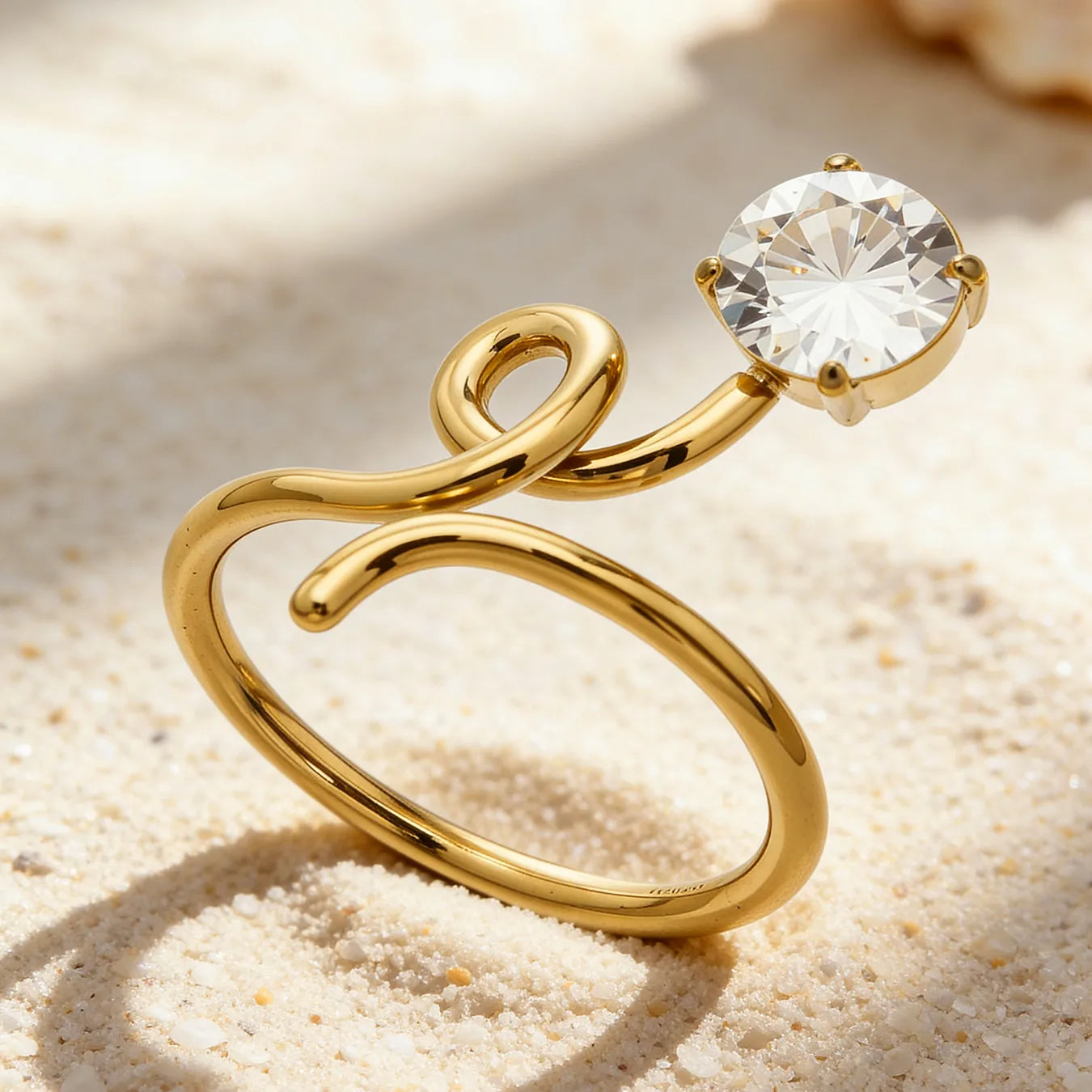 Gold ring with a diamond on a sandy background