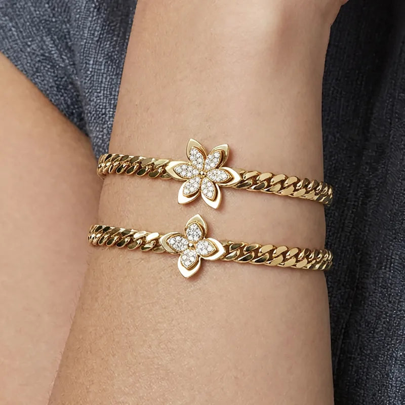 Gold bracelets with floral designs on a wrist