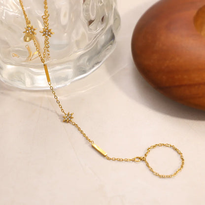 Gold necklace with star-shaped pendant on a white surface