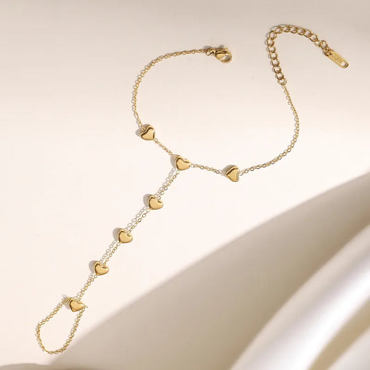 Gold necklace with heart-shaped pendants on a beige background