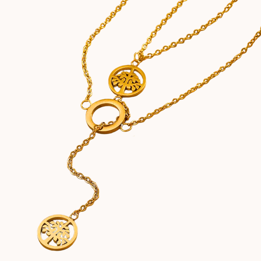 Gold necklace with circular tree pendants on a white background