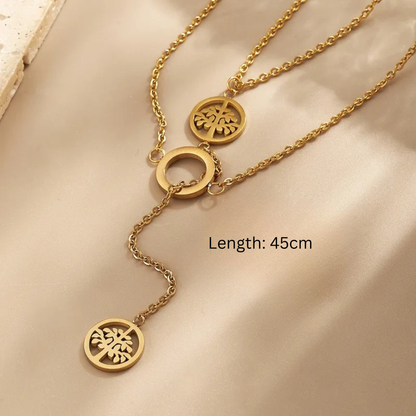 Gold necklace with three circular pendants on a beige fabric background