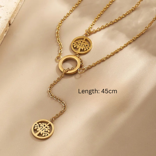 Gold necklace with three circular pendants on a beige fabric background