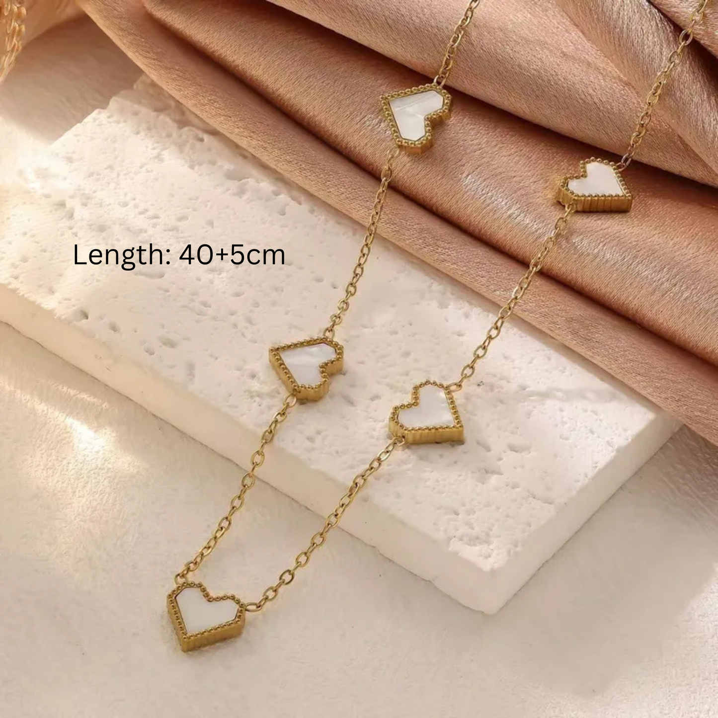 Gold necklace with white heart pendants 