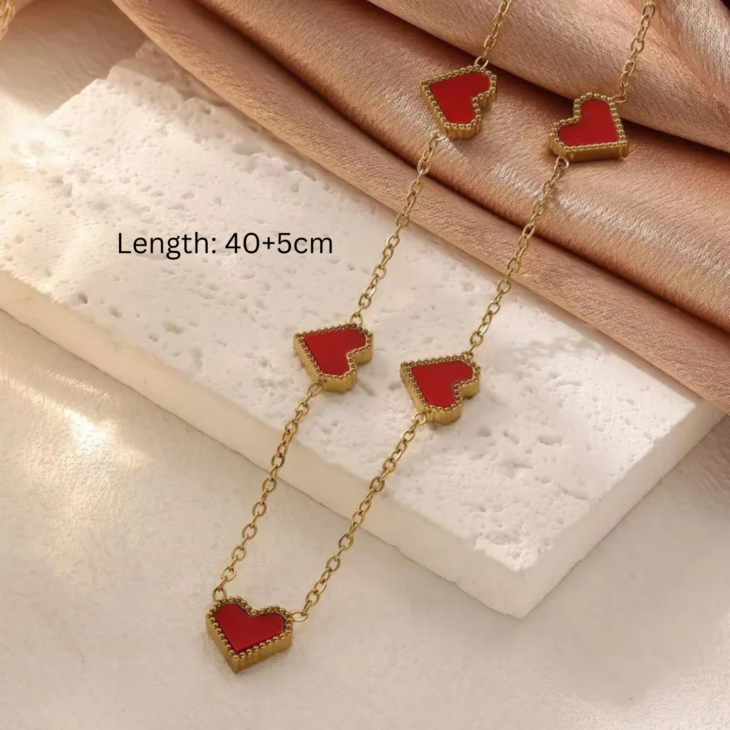 Gold necklace with red heart pendants 
