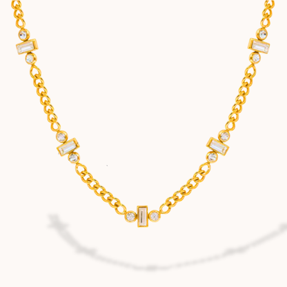 Gold necklace with diamond accents on a white background