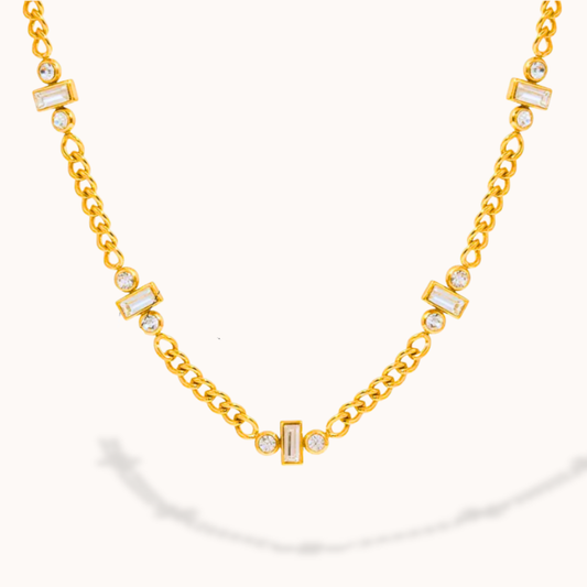 Gold necklace with diamond accents on a white background