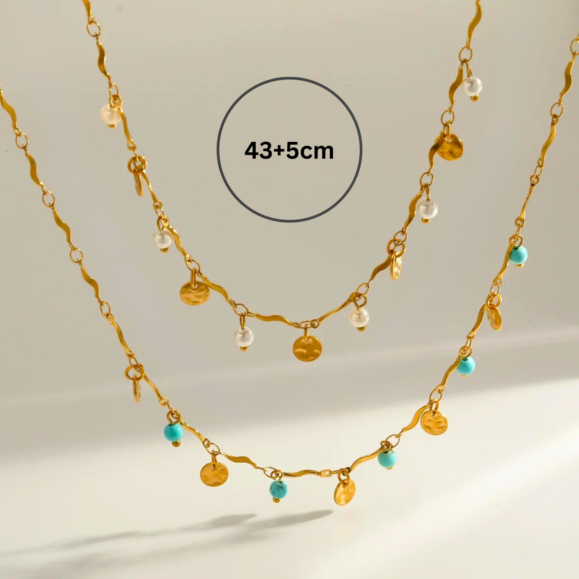 Gold necklace with beads on a light background