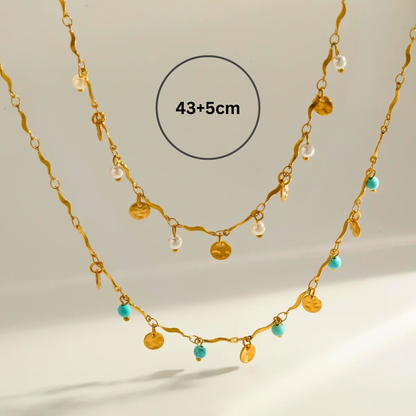 Gold necklace with beads on a light background