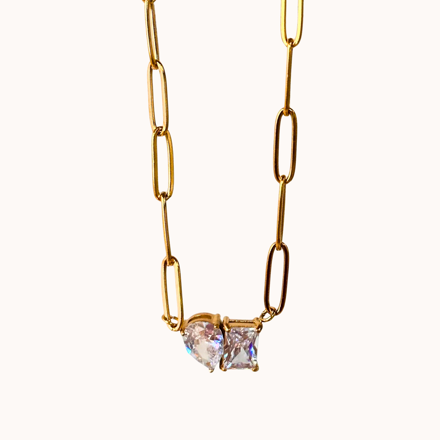 Gold chain necklace with a heart-shaped diamond pendant on a white background