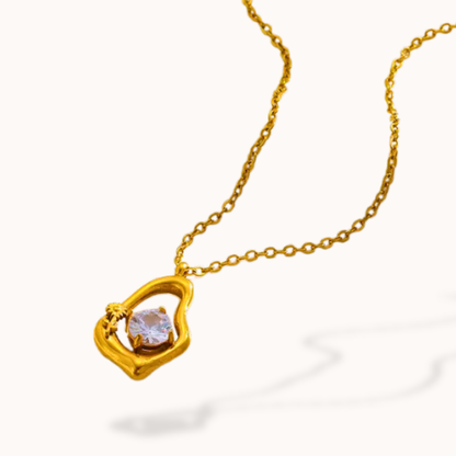 Gold necklace with a heart-shaped pendant on a white background