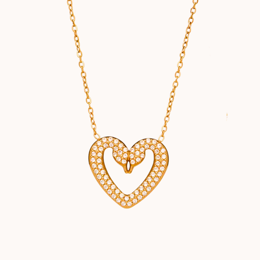 Gold heart-shaped necklace with diamonds on a white background