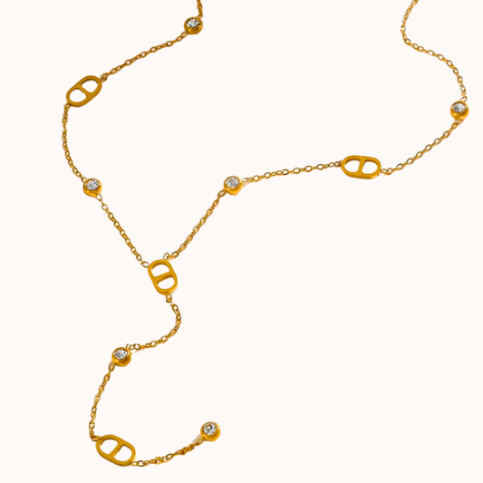 Gold necklace with diamond-like stones on a white background