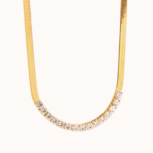 Gold necklace with embedded crystals on a white background