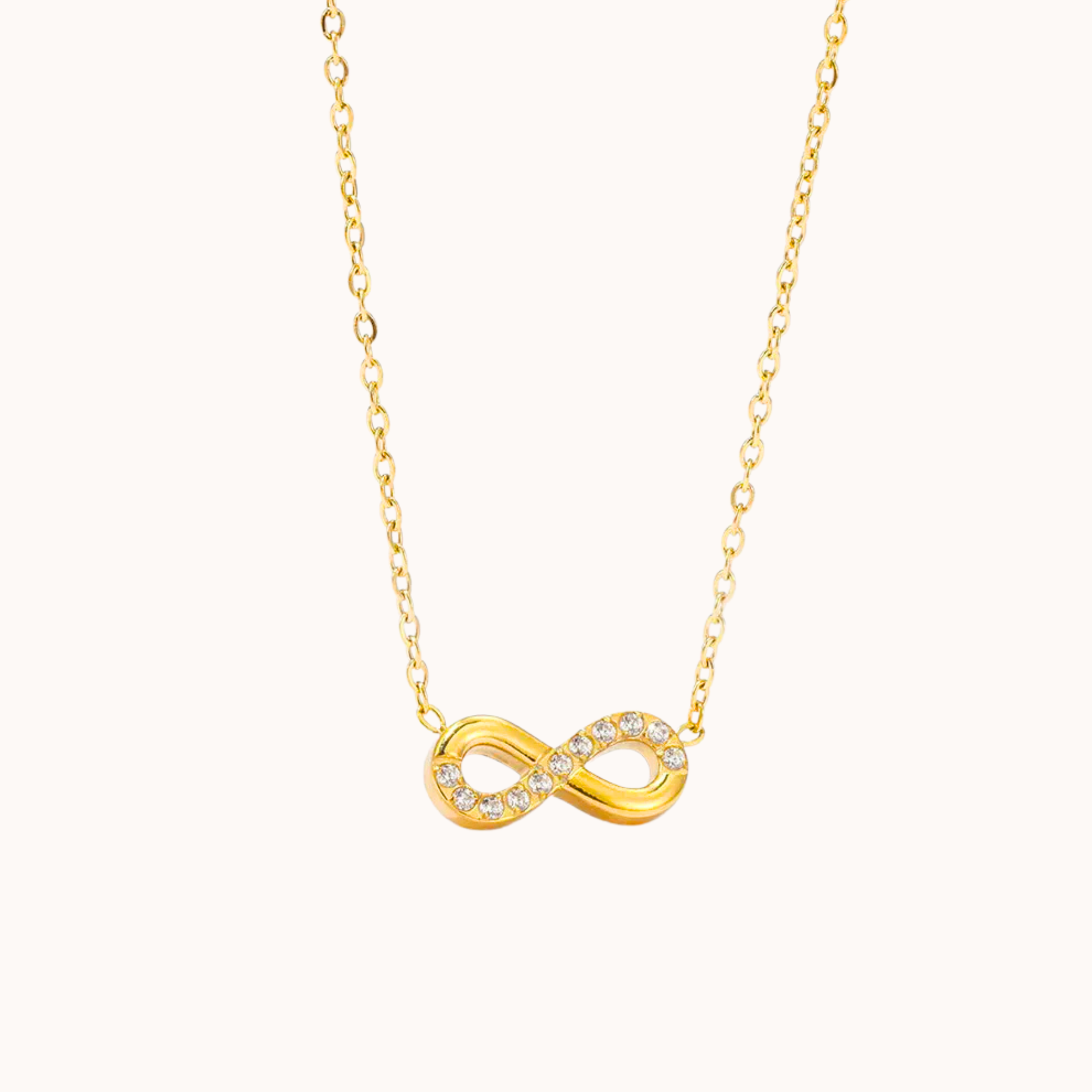 Gold infinity necklace on a white background