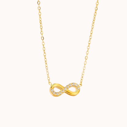Gold infinity necklace on a white background