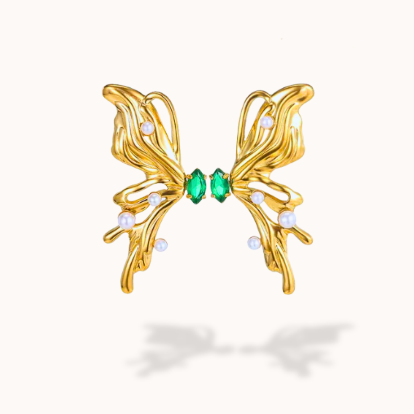 Gold butterfly-shaped earring with green gemstones on a white background